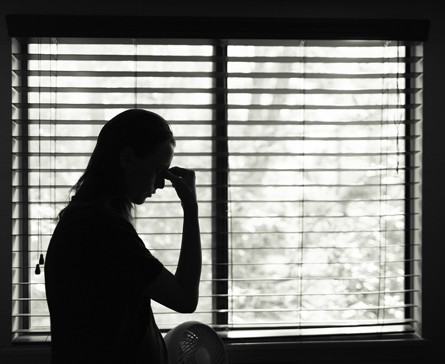 tired woman in front of window 