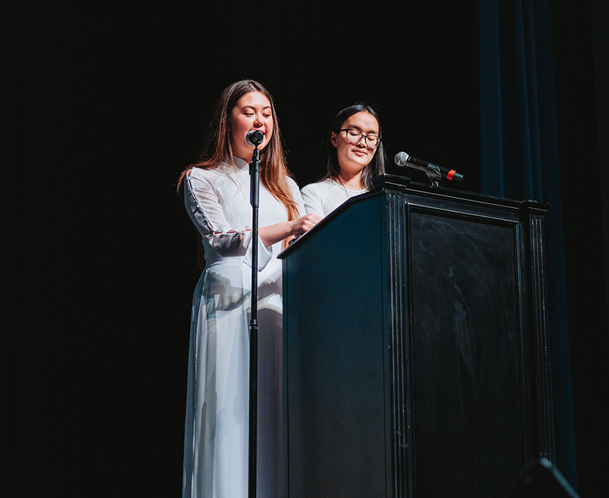 Michelle (pictured right) and Lauren Le (neurobiology '25) wear traditional Vietnamese áo dài as MCs for UCI Vietnamese Student Association's biggest event of the year, Rose Pageant (photo courtesy of Long Truong).