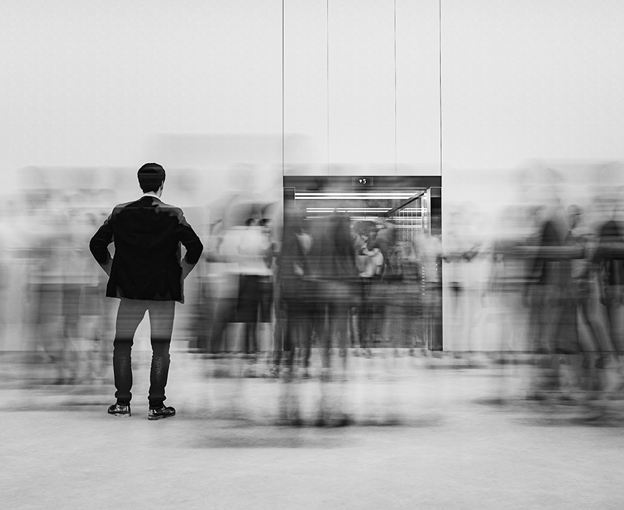 person standing outside crowded elevator