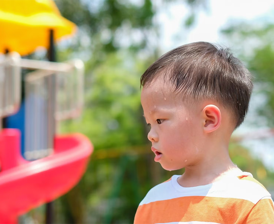 child at playground sweating