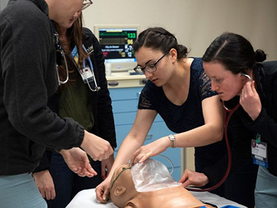 Students taking vital signs to a patient